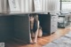 A woman sitting under a desk in a room.