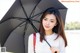 A woman holding a black umbrella in her hand.