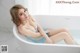 A woman sitting in a bathtub with her legs crossed.