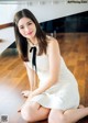 A woman in a white dress sitting on the floor.