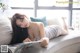 A woman laying on a couch reading a magazine.