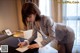 A woman in a business suit writing on a piece of paper.