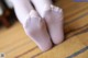 A pair of white socks sitting on top of a wooden floor.